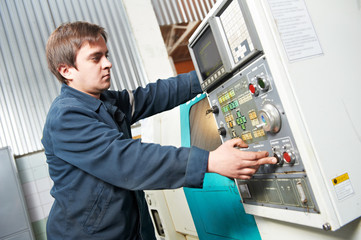 Naklejka na ściany i meble worker operating machine at workshop