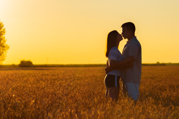 Young couple kissing in the field of wheat