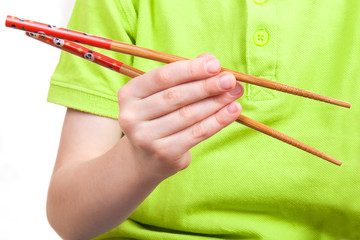 The kid hand holds traditional asian chopstick - 63507226
