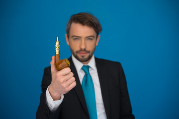 businessman with e-cigarette wearing suit and tie on blue