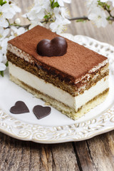 Tiramisu cake on white plate. Blossom apple