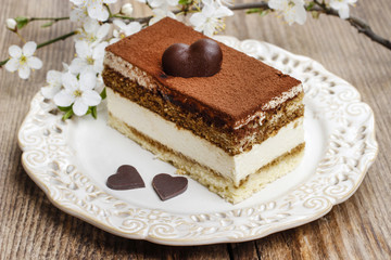 Tiramisu cake on white plate. Blossom apple