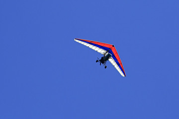Trike (hang glider with a motor) against the blue sky.