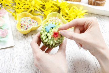 Woman decorates easter cupcakes