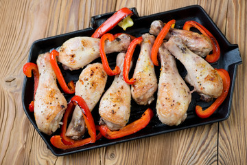 Baked chicken legs with grilled bell pepper slices, above view