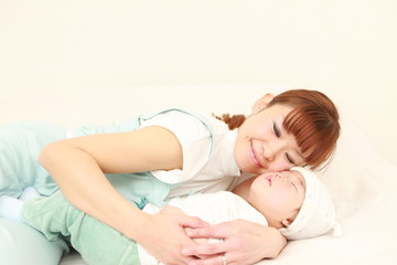 Obraz na płótnie Canvas 子供を寝かせる母親