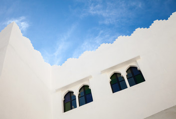 Fototapeta na wymiar White walls, windows and blue sky. Madina, old part of Tangier,