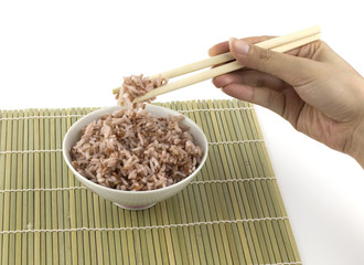 Cooked red rice got clamped by chopstick