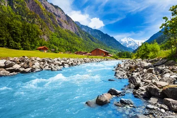 Fotobehang Europese plekken Zwitsers landschap met rivierbeek en huizen
