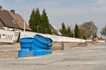 Fototapeta na wymiar Strassenbauarbeiten und blaue Rohr-Bögen aus Kunststoff