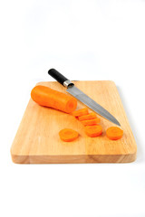 Sliced carrots and a knife on a cloth timber