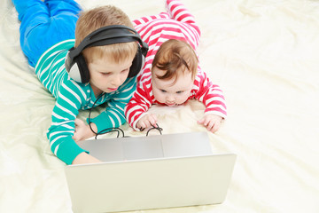 little brother and sister with laptop at home