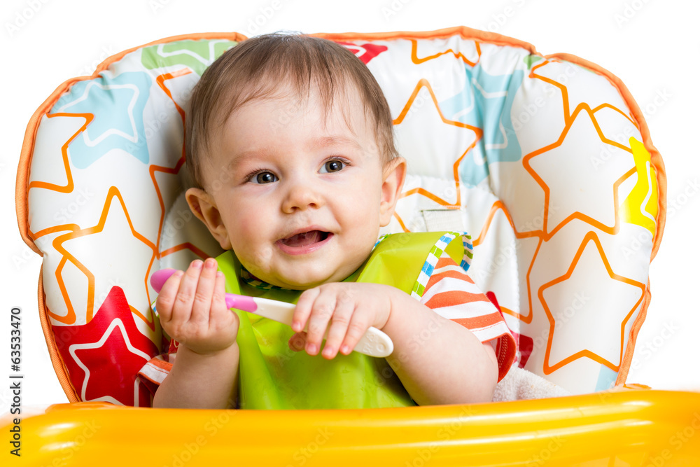 Wall mural smiling baby boy with spoon