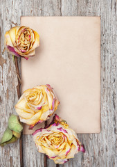 Dry roses and paper on the old wood