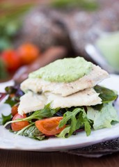 Fried white fish fillet with salad of tomatoes, arugula, herbs