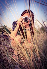 Pretty photographer is shooting the grassland