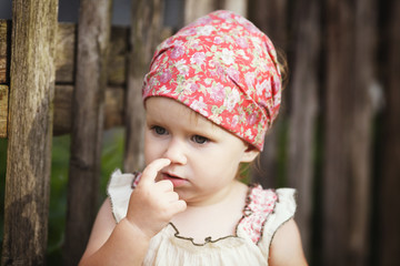 little girl with finger in her nose