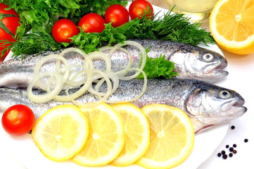 two rainbow trout with lemon and fresh vegetables