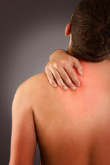 Young male eith neck pain against