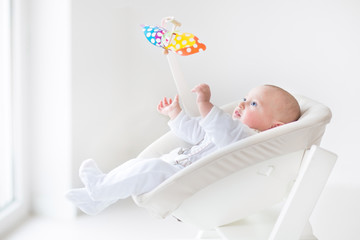 Cute newborn baby boy watching a colorful mobile toy