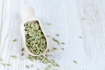fennel seed in a wooden scoop on table