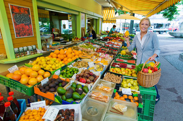 Frau am Obstmarkt mit Einkaufskorb