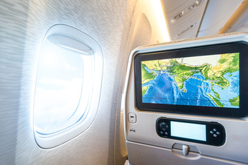 Seat monitor near window in passenger plane.