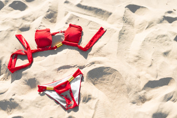 Red swimwear on sand. Holidays and vacations.