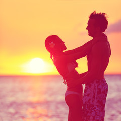 Romantic couple embracing kissing on beach sunset