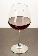 A glass filled with wine on a black table