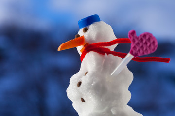 Christmas snowman with pink gloves outdoor. Winter season.