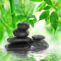 Obraz na płótnie Canvas spa Background - black stones and bamboo on water