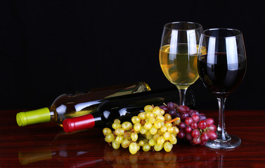 Wine Bottles and Glasses of Wine over black background.