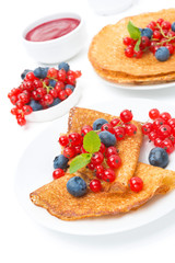 crepes with red currants, blueberries and jam for breakfast