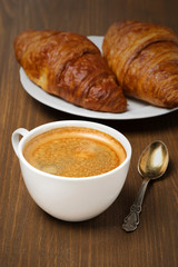cup of coffee and fresh croissants, vertical