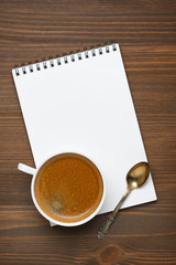 Obraz na płótnie Canvas cup of coffee, spoon and note pad, concept photo