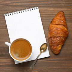 cup of espresso, fresh croissant and notepads, photo concept
