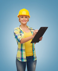 smiling woman in helmet with clipboard