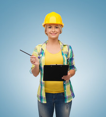 smiling woman in helmet with clipboard