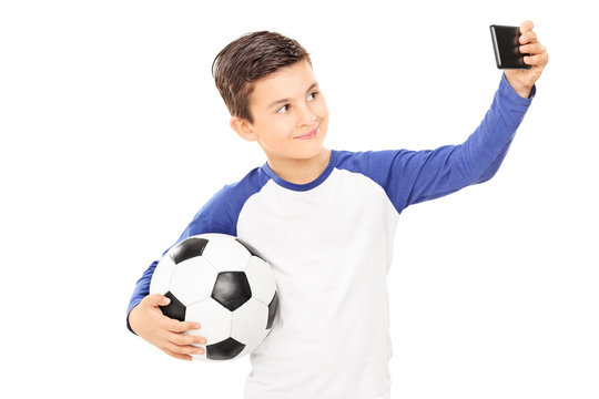 Boy holding football and taking a selfie