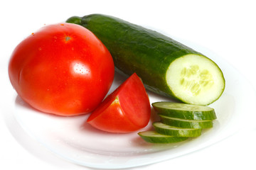 Slised tomatoes and cucumber on a white plate