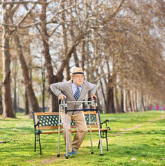 Senior standing up with walker in park