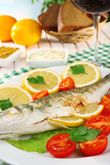 Delicious grilled fish on plate on table close-up