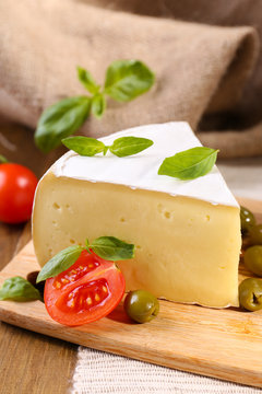 Tasty Camembert cheese with tomatoes, olives and basil,