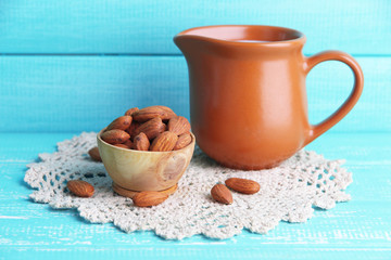 Almond milk in jug with almonds in bowl,
