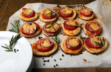 Small pizzas on baking paper close up