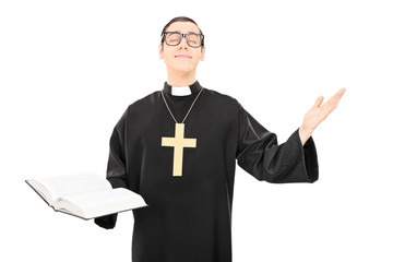 Young cheerful priest praying to god