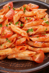 Pasta with tomato sauce on plate on table close-up