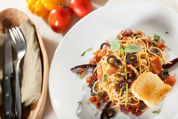 spaghetti, chef in uniform holding a dish of seafood spaghetti