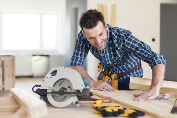 Smiling carpenter checking result of his work